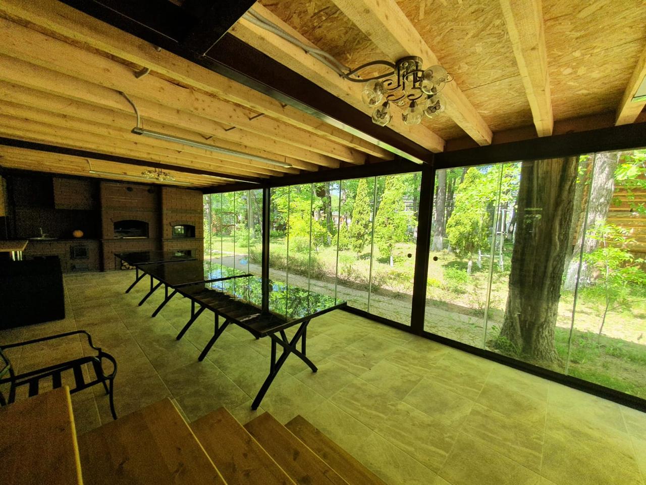 Раздвижное безрамное остекление террасы с панорамным видом на сад